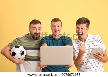 Happy men after winning of their sports bet on color background Royalty-Free Stock Photo #2075673958