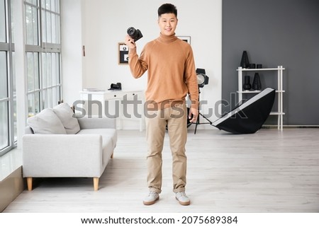 Young Asian photographer in studio