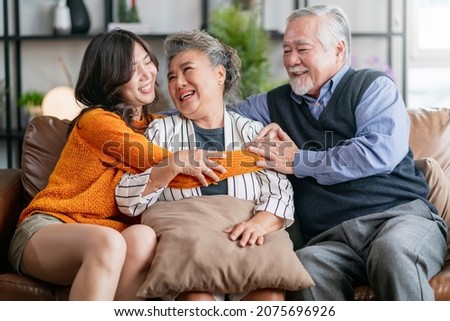 happiness asian family candid of daughter hug grandparent mother farther senior elder cozy relax on sofa couch surprise visiting in living room at home,together hug cheerful asian family at home Royalty-Free Stock Photo #2075696926