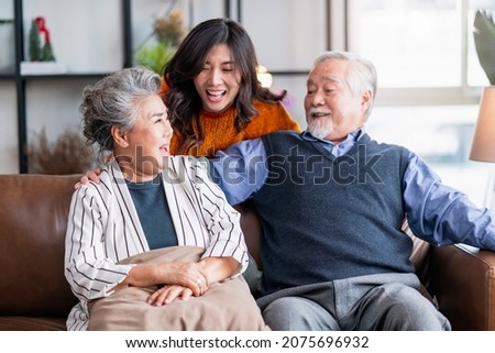happiness asian family candid of daughter hug grandparent mother farther senior elder cozy relax on sofa couch surprise visiting in living room at home,together hug cheerful asian family at home Royalty-Free Stock Photo #2075696932