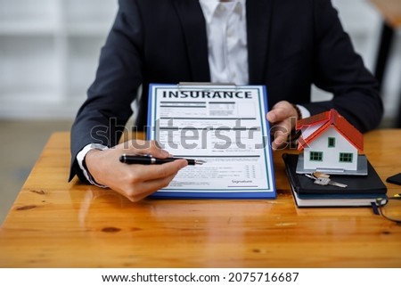 Real estate broker agent presenting and consult to the customer to decision making sign insurance form agreement, buy and sell home model, concerning mortgage loan offer for and house insurance