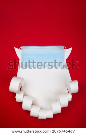 Santa Claus beard with face mask on red background, creative minimal concept of Christmas and New Year safe celebration