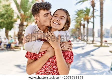 Young hispanic couple smiling happy and hugging standing at the city.