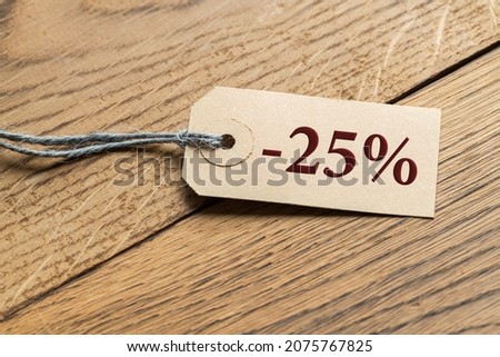 Hangtag with title "-25%" on wooden background