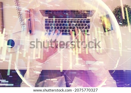 Double exposure of woman hands working on computer and financial theme hologram drawing. Top View. Business concept.