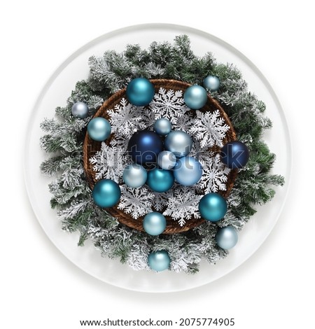 merry christmas decoration, green wreath garland with pine cones and snowflakes around a basket full of blue and turquoise xmas balls, isolated on white background, top view, useful for centerpieces