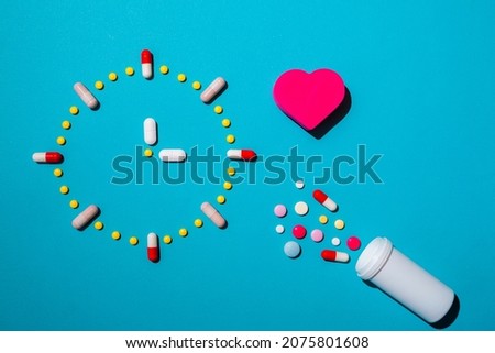 Clock made from colorful pills as a concept of taking medicine in time, by prescription. Addiction from drugs, painkiller capsules.