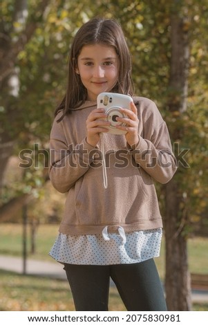 Girl playing with white camera