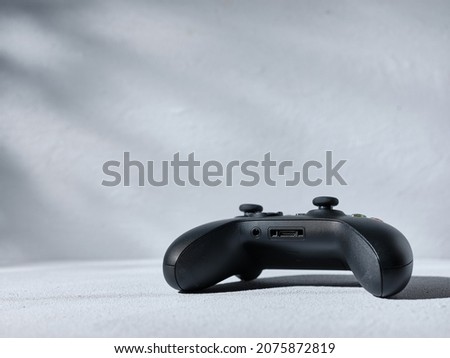 Black gamepad on gray background