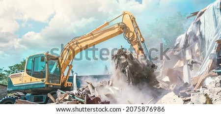 Excavator breaking house. Old building demolishing Royalty-Free Stock Photo #2075876986