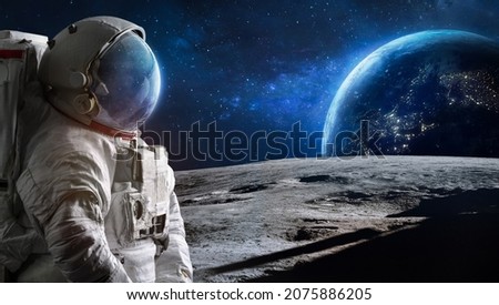 Astronaut on Moon surface. Spaceman moonwalks. Artemis lunar program and Earth. Elements of this image furnished by NASA