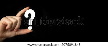 Banner question mark sign in hand. Question icon, symbol on a black background photo