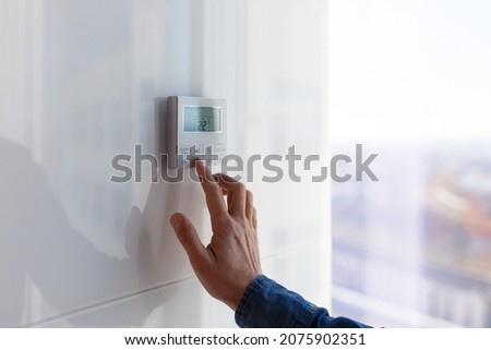 The air conditioning and heating control panel for the apartment and office is located on a white wall Royalty-Free Stock Photo #2075902351