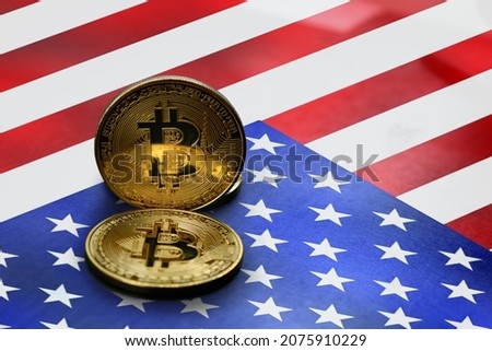close-up gold colored bitcoin coin on american flag