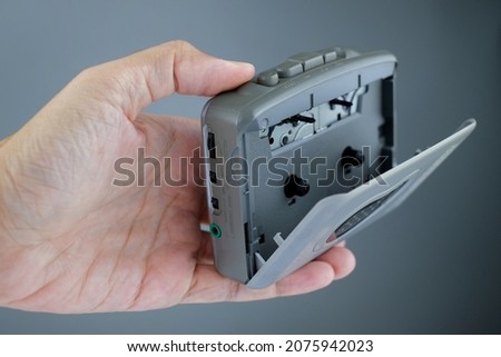 Hand holding vintage cassette player, isolated background. Hand holding classic cassete player.