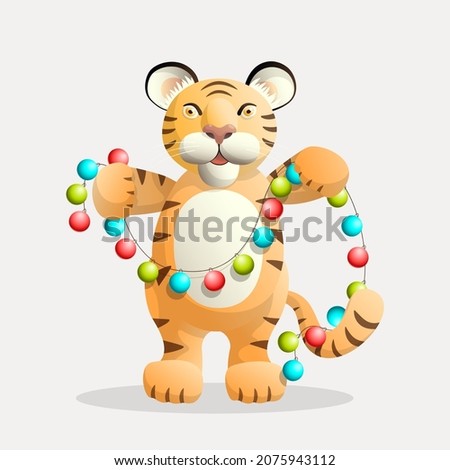 Happy tiger character stands and holds a Christmas garland in its paws.
