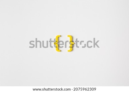 Yellow wooden symbol "bracket" on white background and copy space for social media educational concept