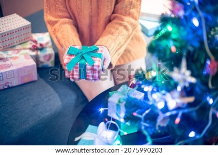 Close up shot of Female hands holding gift box. Copyspace. Christmas, hew year, birthday concept. Festive background with bokeh and sunlight. Magic fairy tale. Shallow depth of field with focus on box
