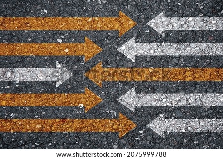 concept of racing and different directions for victory. white arrow and yellow arrow on asphalt road
