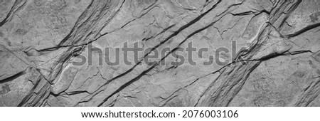 Black white rock texture. Mountain surface. Close-up. Gray stone background with copy space for design. Wide banner.	Panoramic. Royalty-Free Stock Photo #2076003106
