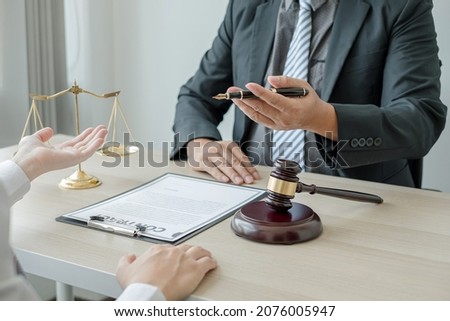 A man lawyer or a judge counseling clients about judicial justice and prosecution with scales, judges gavel, legal documents legal services concept.