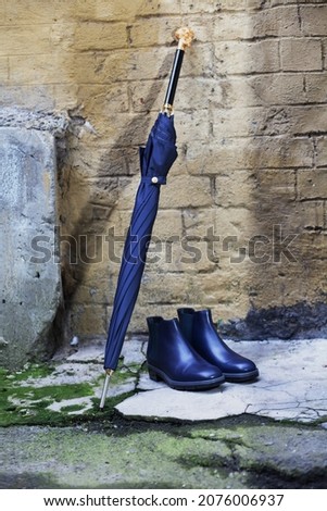 Men's shoes with an umbrella and a walking stick are on the street