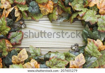 Autumn leaves and acorns border wood sign