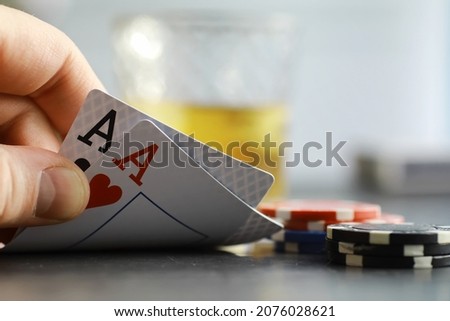 Gambling Card games for money. Texas Hold'em Poker. Cards in hand, playing chips, deck of cards of alcohol in a glass. Royalty-Free Stock Photo #2076028621