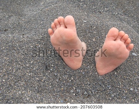 Feet buried in the sand at the beach Royalty-Free Stock Photo #207603508