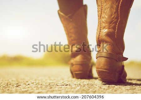Close up low angle female with cowboy boots Royalty-Free Stock Photo #207604396