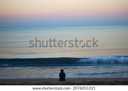 woman sitting in front of the sea at sunrise in mazatlan mexico  Royalty-Free Stock Photo #2076055321
