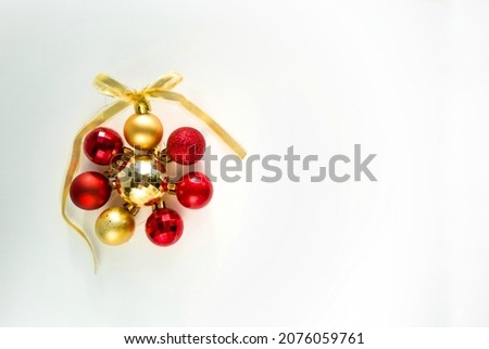 Christmas balls in round. Gold and red christmas ball with ribbon bow on white background. New Year background. Christmas balls close up picture.	
