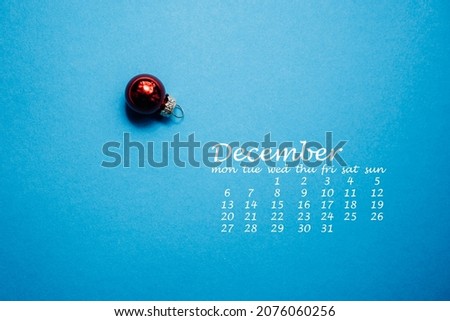 red christmas ball on blue background, calendar