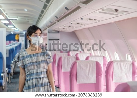 woman wearing protective face mask sitting in airplane or public transportation, protection Coronavirus disease infection, tourist ready to travel. Next Normal, tourism and reopening concept