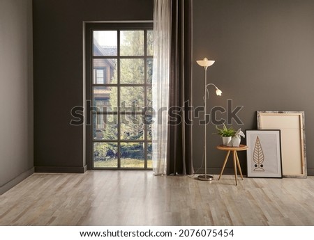 Living room corner grey wall background, windows garden view, lamp, vase of plant, chair and frame style. Royalty-Free Stock Photo #2076075454