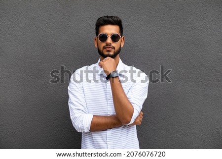 Charming young indian man in casual wear isolated on gray background Royalty-Free Stock Photo #2076076720