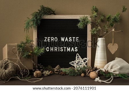 Zero waste Christmas concept. Natural materials, wood, paper, packaging, fir branches cones nuts. Frame with an inscription. Greeting card in eco-style, muted earthy brown beige shades. New Year 2022