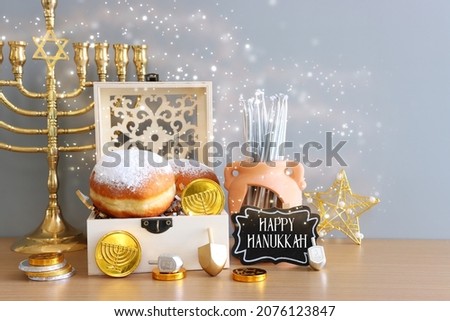 Religion image of jewish holiday Hanukkah background of spinning tops with letters that mean, A 
GREAT MIRACLE HAPPENED HERE, donuts and menorah (traditional candelabra) 