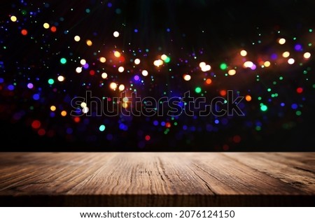 wooden table in front of glitter colorful bokeh lights. For product presentation