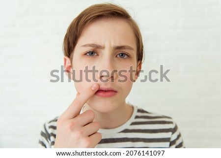 Teen boy looks at his first mustache in mirror, puberty period, early adulthood Royalty-Free Stock Photo #2076141097