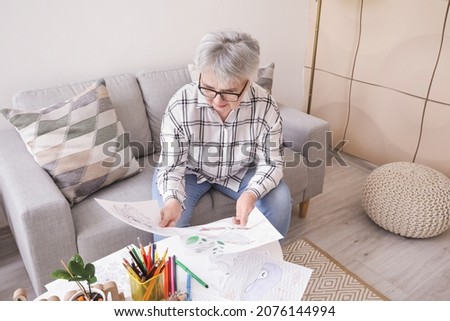 Senior woman coloring picture at home