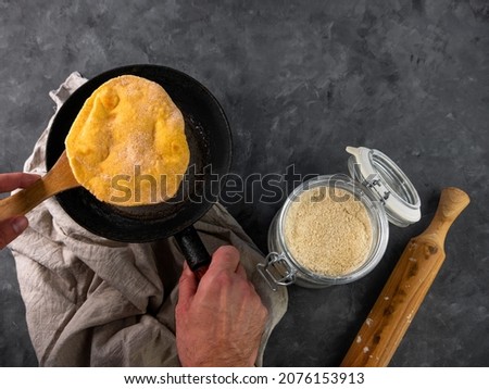 Homemade corn flatbread meal frying pan in male hand. Handmade mexican tortilla for wrapping.Traditional latin cornmeal dough bread top view Authentic cuisine Taco Quesadilla cooking recipe ingredient
