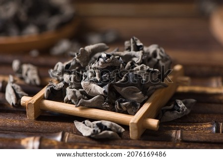 Dry black fungus or wood ear mushroom on wood background. Royalty-Free Stock Photo #2076169486