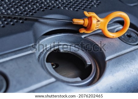 Engine oil filler tube with dipstick. Car repair and maintenance Royalty-Free Stock Photo #2076202465