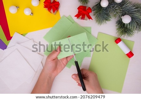 Paper napkins, scissors, colored paper on a light table. Children's Christmas craft. Step-by-step instruction. Step 4.