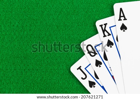 Royal flush poker playing cards on green felt background