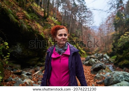 Woman travel photographer with camera in a vibrant autumn scene in the mountains