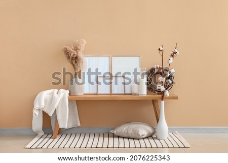 Interior of modern room with bench, decor and blank frames