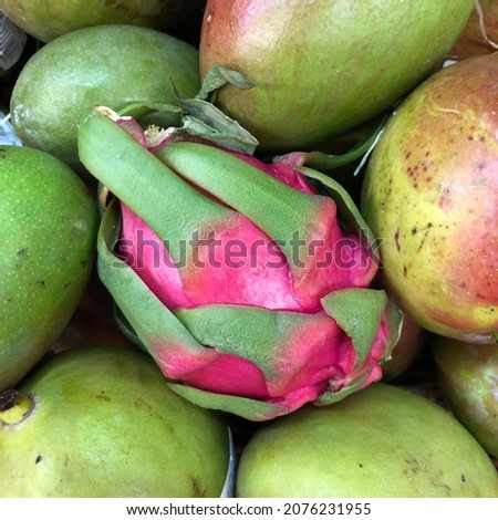 Macro photo tropical pink pitaya and mango fruit. Stock photo green tropical fruit mango and pitaya
