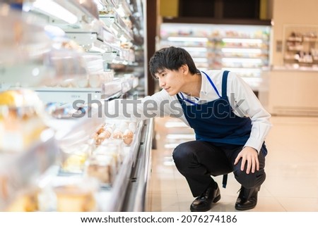 Young staffs working at a supermarket Royalty-Free Stock Photo #2076274186